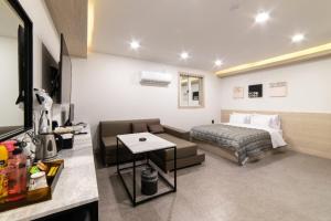 a bedroom with a bed and a couch and a table at 전주 타임모텔 in Hyoja-dong