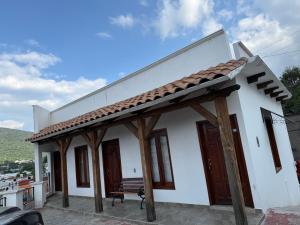 Hotel Carretas 2 في جالبان: مبنى أبيض أمامه مقعد