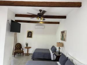 Hotel Carretas 2 في جالبان: غرفة نوم مع مروحة سقف وسرير