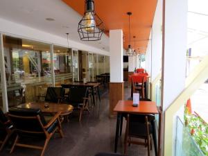 a restaurant with tables and chairs in a room at Gandasari Hotel in Bandung
