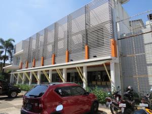 a red car parked in front of a building at Gandasari Hotel in Bandung