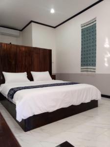 Un dormitorio con una cama grande con cabecero de madera. en Le Charme Pakbeng Villa, en Ban Pho Touane