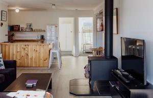 sala de estar con chimenea y cocina en Cedar House ~ Family Fun!, en Bicheno