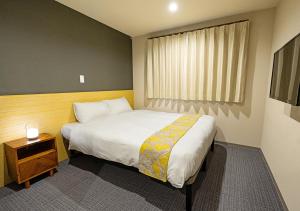 a bedroom with a large bed and a window at Stay SAKURA Kyoto Station Shichijo in Kyoto