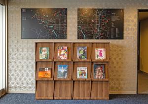 a book shelf with books and a map on a wall at Stay SAKURA Kyoto Station Shichijo in Kyoto