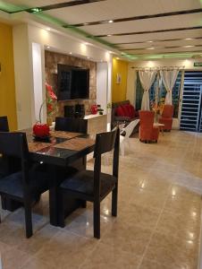 a dining room with a table and a living room at Alquiler por días en Armenia Casahotel Villahermosa in Armenia