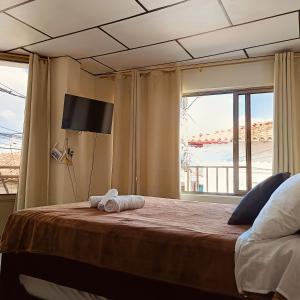 RuiosucioにあるApartaestudio central con balcón y wifi en Riosucioのタオルが敷かれたベッドのある寝室