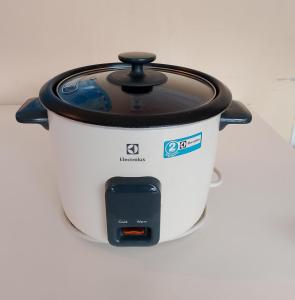 a slow cooker with a cell phone next to it at Prima B&B Hostel in Sandakan