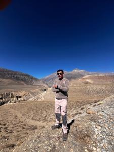 Ein Mann steht auf einem Felsen in der Wüste in der Unterkunft Peace guesthouse cottage in Pokhara