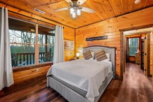 a bedroom with a bed and a ceiling fan at Views, Arcade Game, Fire-pit, Hot Tub, Private! in Sevierville