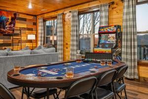 a room with a poker table and a game room at Views, Arcade Game, Fire-pit, Hot Tub, Private! in Sevierville