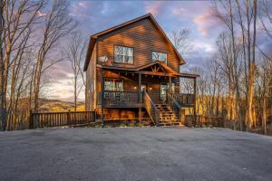 a large wooden house with a porch and stairs at Views, Arcade Game, Fire-pit, Hot Tub, Private! in Sevierville