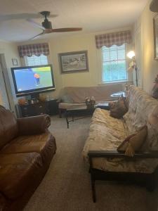 a living room with a couch and a flat screen tv at Charleston, SC themed - PRIVATE 1 QUEEN BED 1 BATH APARTMENT 2 FUTONS THAT FOLD OUT FLAT TO SLEEP ON & LEATHER LOVE SEAT GAS LOGS IN LIVING ROOM FULL KITCHEN POKER BUMPER POOL TABLE CONVENIENTLY LOCATED IN COLUMBIA SOUTH CAROLINA 1 QUEEN BED & 2 SOFA BEDS in Columbia +18 photos