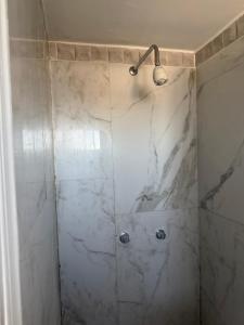 a bathroom with a shower with white marble walls at Ensueño 631 in Heroica Nogales
