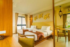 a hotel room with two beds and a desk at The Signature Hotel @ Thapae in Chiang Mai
