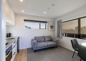 Una sala de estar con una silla y una cocina. en Central Studios, en Westport