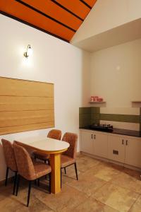 a kitchen with a table and chairs in a room at wayanadjunglevillas in Kenichira