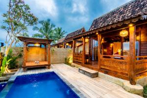 a villa with a pool and a house at Kamania Villa Ubud by Dhananjaya Hospitality in Tampaksiring
