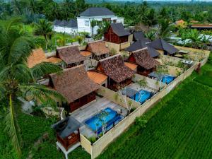 an aerial view of a house with a swimming pool at Kamania Villa Ubud by Dhananjaya Hospitality in Tampaksiring