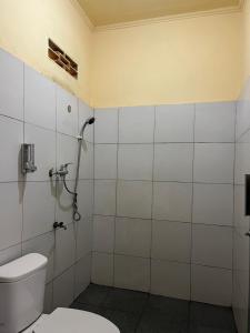 a bathroom with a toilet and a shower at Dragonfly Senaru Lodge in Senaru