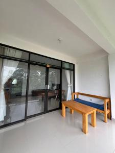 a wooden bench in a room with glass windows at Dragonfly Senaru Lodge in Senaru