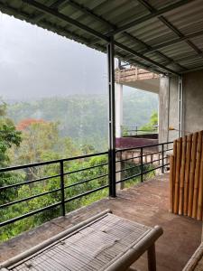 a balcony with a bench and a view of the mountains at Dragonfly Senaru Lodge in Senaru