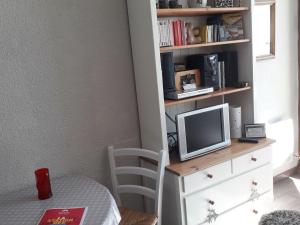 Ein Schlafzimmer mit Schreibtisch, Fernseher und Bücherregal in der Unterkunft Studio charmant avec terrasse et parking au Praz de Lys - FR-1-815-19 in Le Praz de Lys