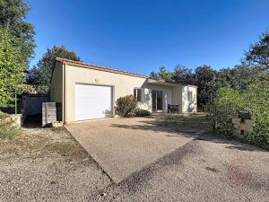 une maison avec une porte de garage blanche dans une allée. dans l'établissement Maison climatisée avec parking à Lamalou-les-Bains - FR-1-451-222, à Lamalou-les-Bains