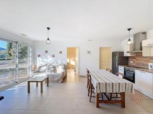 une cuisine et un salon avec une table dans l'établissement Maison climatisée avec parking à Lamalou-les-Bains - FR-1-451-222, à Lamalou-les-Bains