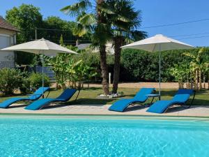 a group of chairs and umbrellas next to a pool at Charmant Loft à La Flèche - Idéal pour Famille ou Couple - FR-1-410-483 in Saint-Germain-du-Val