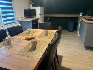 a wooden table with chairs and a kitchen with a tableablish at Charmant Loft à La Flèche - Idéal pour Famille ou Couple - FR-1-410-483 in Saint-Germain-du-Val
