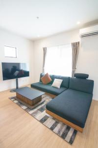 a living room with a couch and a tv at Burikina Terrace in Nago