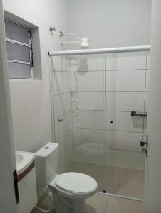 a bathroom with a toilet and a glass shower at Cozy air-conditioned house in Sumaré in Sumaré