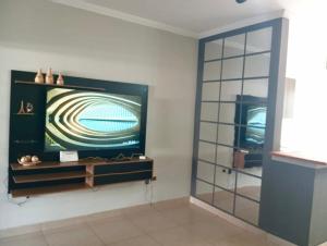 a flat screen tv on a wall in a room at Cozy air-conditioned house in Sumaré in Sumaré