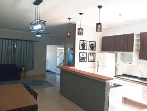 a kitchen and living room with a counter top at Cozy air-conditioned house in Sumaré in Sumaré +5 photos