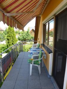 uma varanda com espreguiçadeiras e uma janela em Ahornweg Ferienwohnung em Gebsattel
