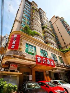 a building with cars parked in front of it at Baiyuan Hotel Changgang Baogang Avenue Metro Station Branch in Guangzhou