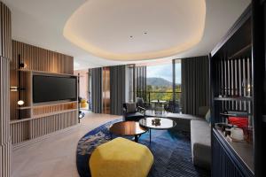 a living room with a couch and a tv at Hotel Indigo Anji by IHG in Anji