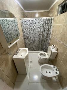 a bathroom with a toilet and a sink and a shower at Alojamiento en Gualeguaychú in Gualeguaychú
