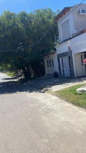 a house with a tree in front of a street at Alojamiento en Gualeguaychú in Gualeguaychú