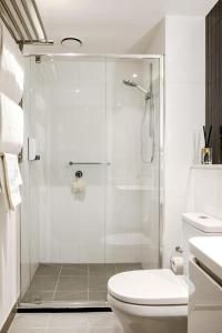 une salle de bain blanche avec douche et toilettes dans l'établissement The Yorkshire Apartments, à Melbourne 13 autres photos