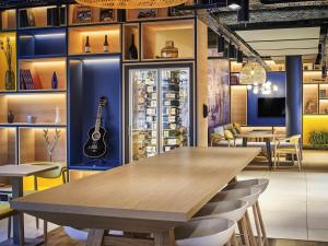 贝休恩ibis Bethune Centre Gare的墙上的餐桌和吉他用餐室