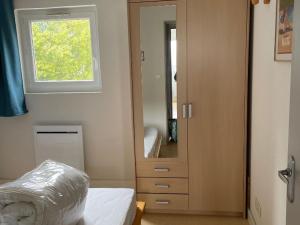 ein Schlafzimmer mit einem Spiegel, einem Bett und einem Fenster in der Unterkunft Appartement spacieux pour 6 avec terrasse et parking privé - FR-1-814-152 in Super Besse