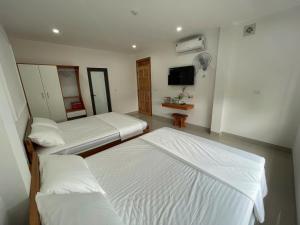 Zimmer mit 3 Betten, einem TV und einem Zimmer mit in der Unterkunft Hotel Thu Trang  + 3 Fotos