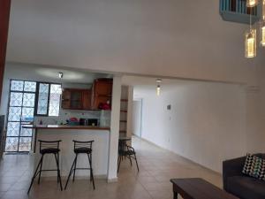 cocina y sala de estar con encimera y taburetes en Residencia COCO 28 Downtown Cancun, en Cancún
