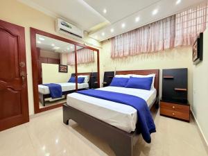 マチャラにあるSuite en Unioroのベッド2台と鏡のある寝室