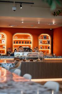 a restaurant with orange walls and tables and chairs at Cheval Maison - The Palm in Dubai