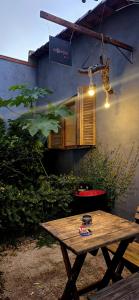 Hostel Barato Zona Sul في بورتو أليغري: طاولة نزهة خشبية أمام المبنى