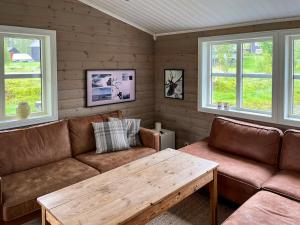 un salon avec un canapé et une table en bois dans l'établissement Mountain Cabin With Views Of Snasahøgarna, à Rundhögen