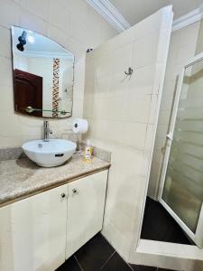 マチャラにあるSuite en Unioroの洗面台と鏡のあるバスルーム